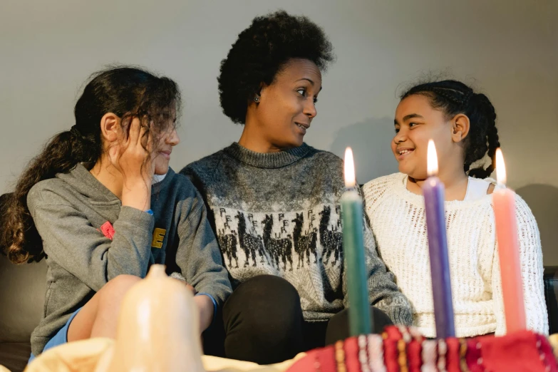 a group of girls sitting around a table with candles, a portrait, pexels contest winner, hurufiyya, happy family, avatar image, profile image, wearing festive clothing