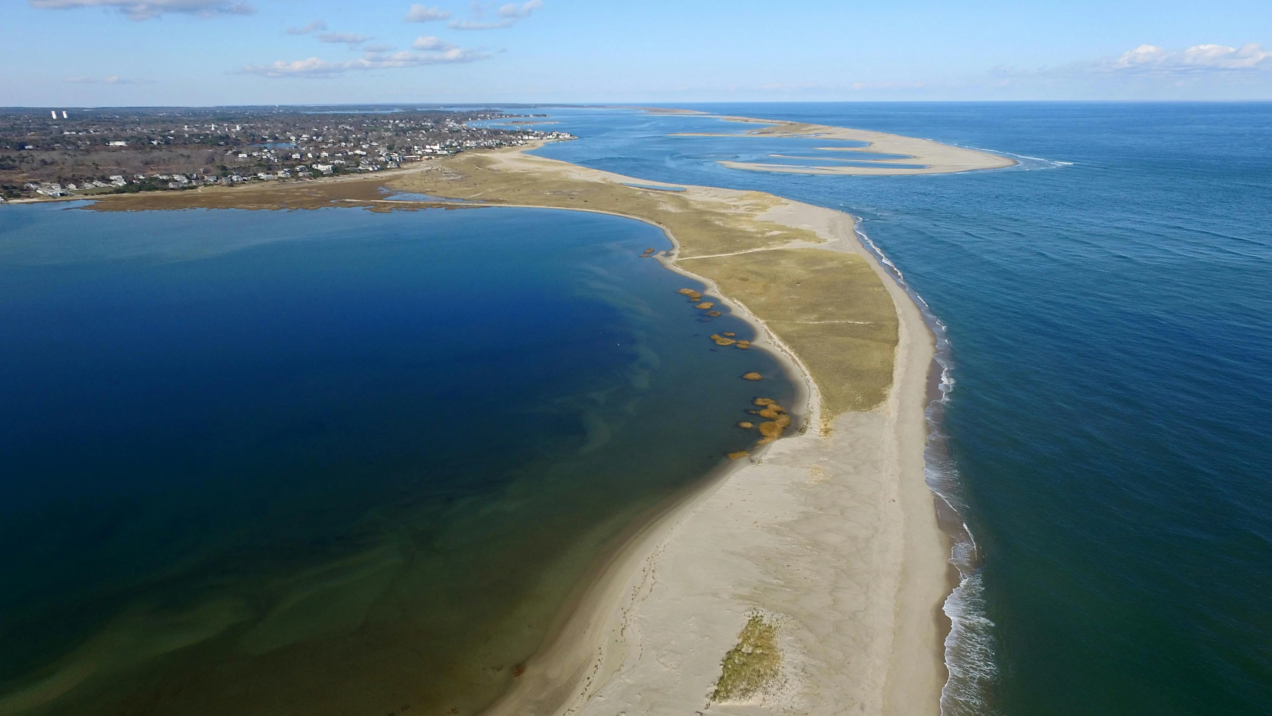 a large body of water next to a sandy beach, unsplash, land art, craigville, helicopter view, 2000s photo, slide show