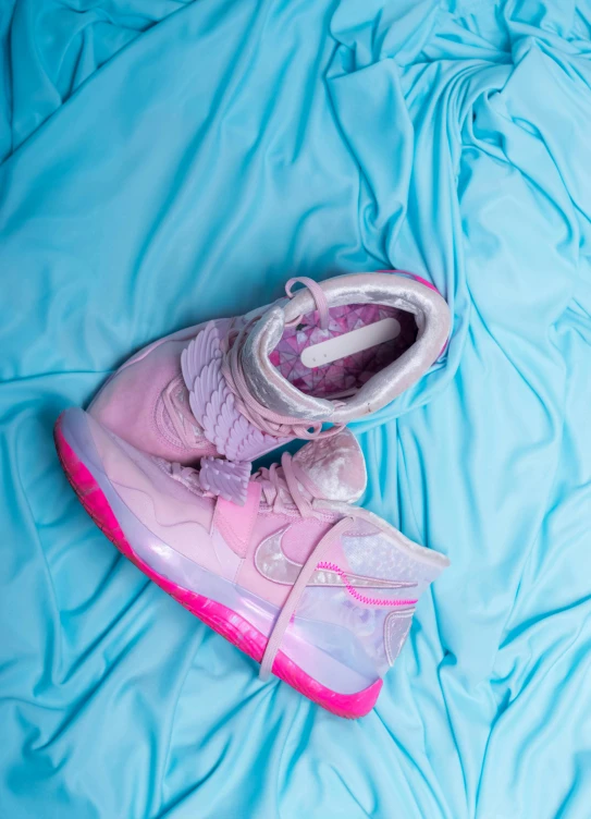 a pair of pink shoes sitting on top of a blue sheet, inspired by Zhu Da, trending on unsplash, renaissance, translucent neon skin, “air jordan 1, made of cotton candy, full - view