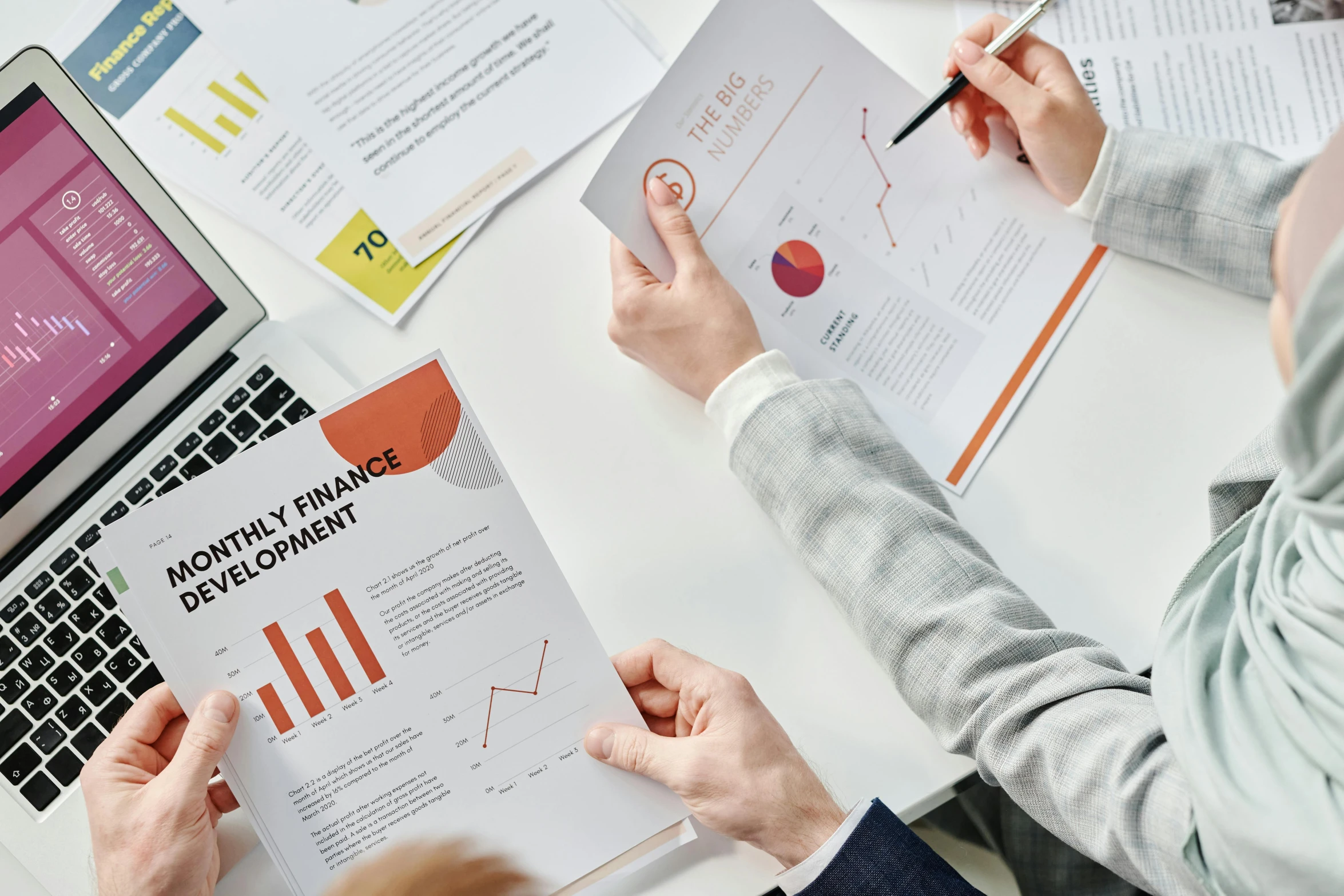 two people sitting at a table with papers and laptops, a screenshot, trending on unsplash, graphs, on grey background, colour print, brochure