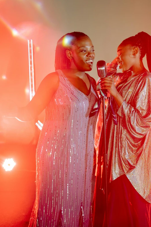 two women standing next to each other holding microphones, an album cover, pexels, happening, glittering light, ( ( dark skin ) ), live performance, holiday