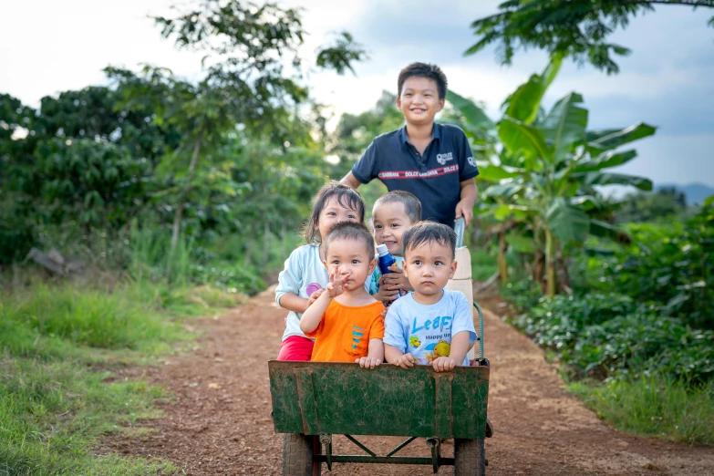 a group of children in a wagon on a dirt road, pexels contest winner, mai anh tran, in the garden, avatar image, portrait image