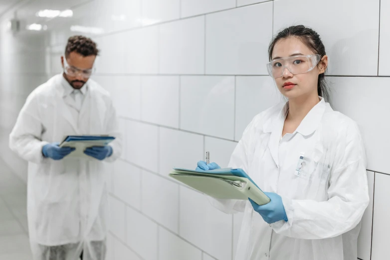 a couple of people in lab coats standing next to each other, pexels contest winner, analytical art, holding a clipboard, wet floors, profile image, thumbnail