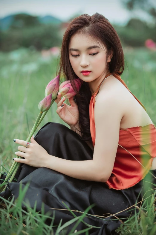 a woman sitting in a field holding a flower, by Tan Ting-pho, trending on pexels, renaissance, black and red silk clothing, square, lily, sleeveless