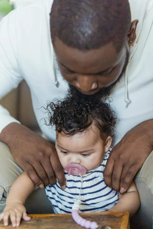 a man is playing with a small child, by Washington Allston, trending on unsplash, renaissance, black curly beard, making out, laying down, soft lulling tongue