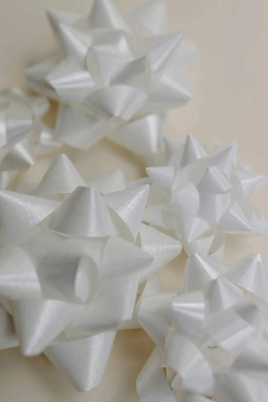 a bunch of white paper stars on a table, a stipple, thick bow, ldpe, up close shot, white finish