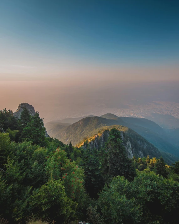 a view of the mountains from the top of a mountain, by Sebastian Spreng, lush evergreen forest, sunset photo, multiple stories, conde nast traveler photo