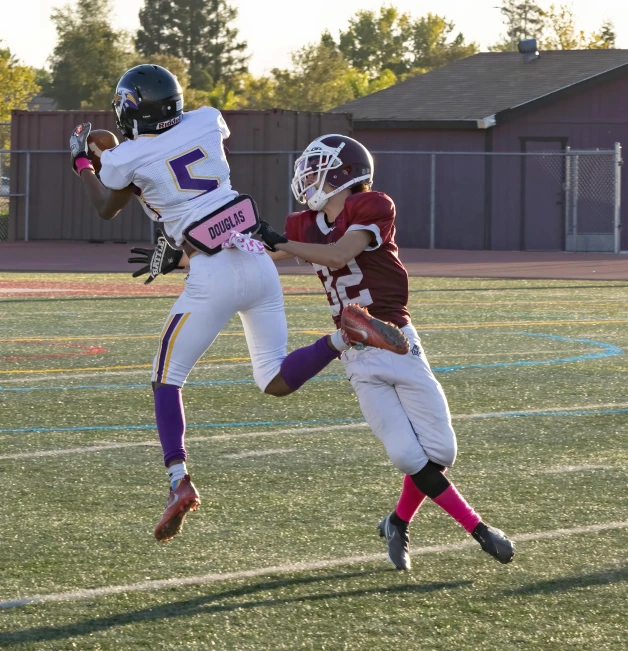 a couple of kids playing a game of football, a digital rendering, by Dan Luvisi, pexels contest winner, brown and magenta color scheme, high midair shot, high school, telephoto shot