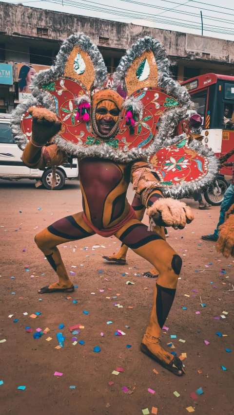 a group of people that are standing in the street, an album cover, by Sam Dillemans, pexels contest winner, afrofuturism, man in a jester costume, on an indian street, floats carnival, a muscular