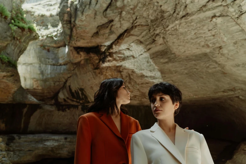 a couple of women standing next to each other, by Winona Nelson, pexels contest winner, bauhaus, natural cave wall, photoshoot for skincare brand, wearing white suit, eva green and gemma arterton