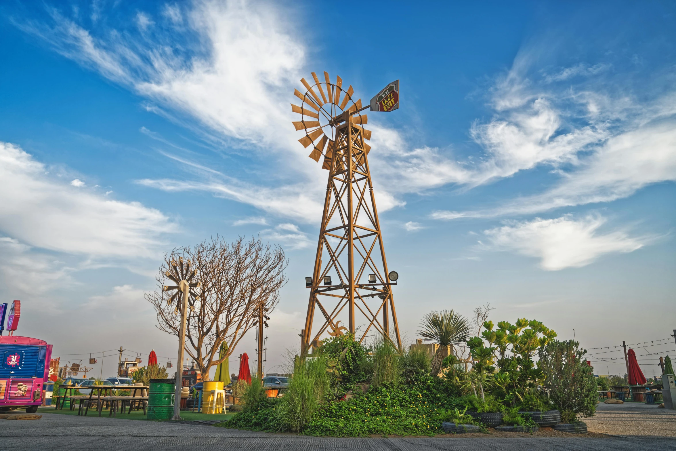 a windmill sitting in the middle of a parking lot, pexels contest winner, environmental art, gardens and fountains, an amusement park in old egypt, rusty metal towers, exterior botanical garden