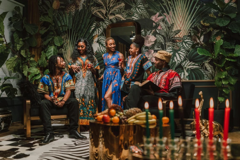 a group of people sitting around a table with candles, by Julia Pishtar, pexels contest winner, black arts movement, wearing an african dress, tropical vibe, standing elegantly, performing a music video