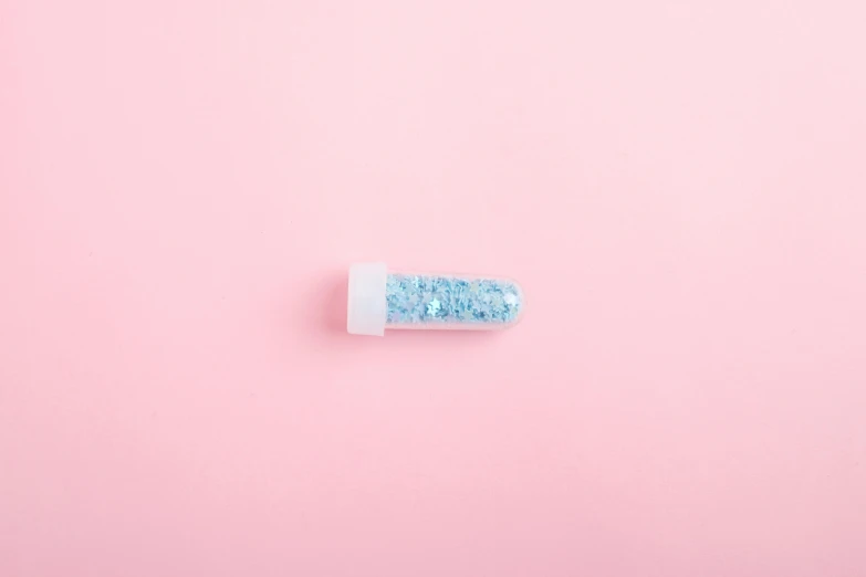 a pill on a pink background, by Elsa Bleda, visual art, blue crystals, made of plastic, glitter, pastel blue