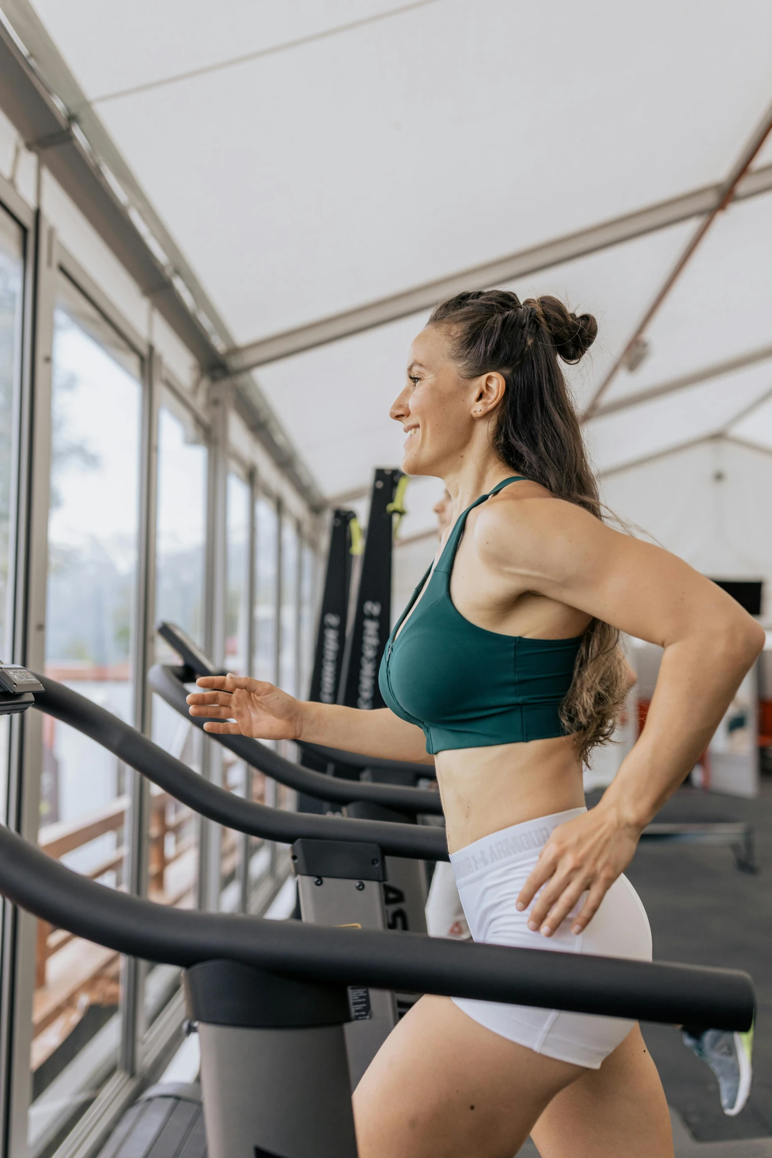 a woman running on a tread machine in a gym, by Arabella Rankin, natural light outside, sydney hanson, profile image, physical : tinyest midriff ever