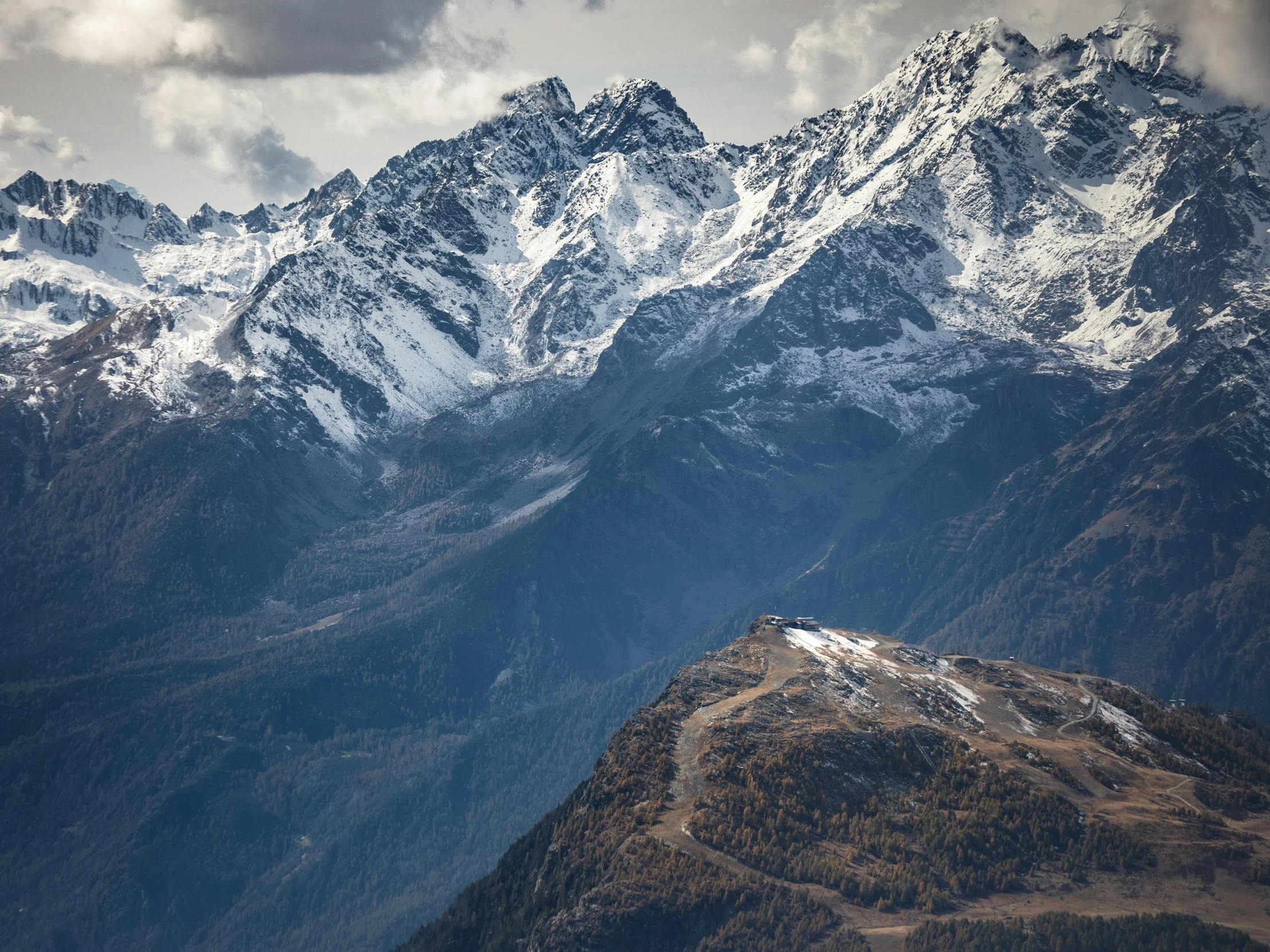 a group of people standing on top of a snow covered mountain, by Peter Churcher, pexels contest winner, autumn mountains, “ aerial view of a mountain, italy, seen from a distance