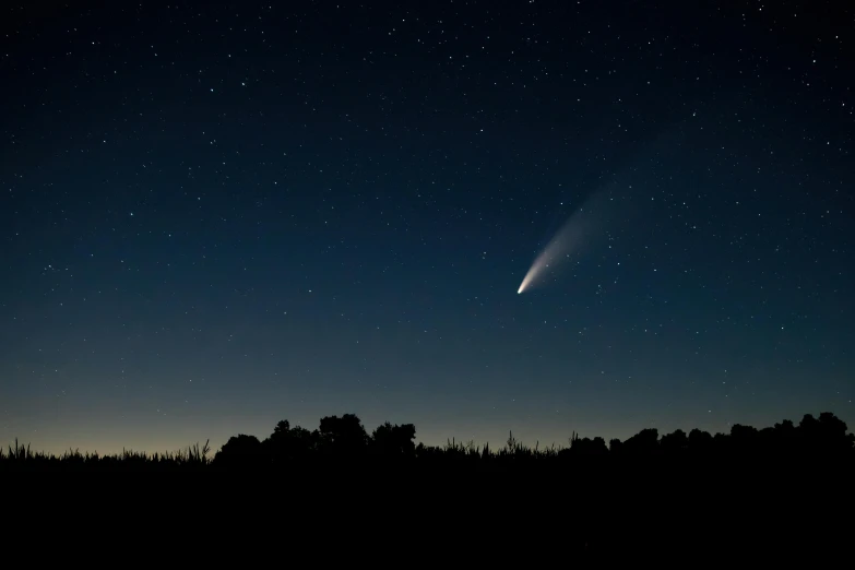 a comet is seen in the night sky, unsplash contest winner, ☁🌪🌙👩🏾, including a long tail, blue fireball, leaked from nasa