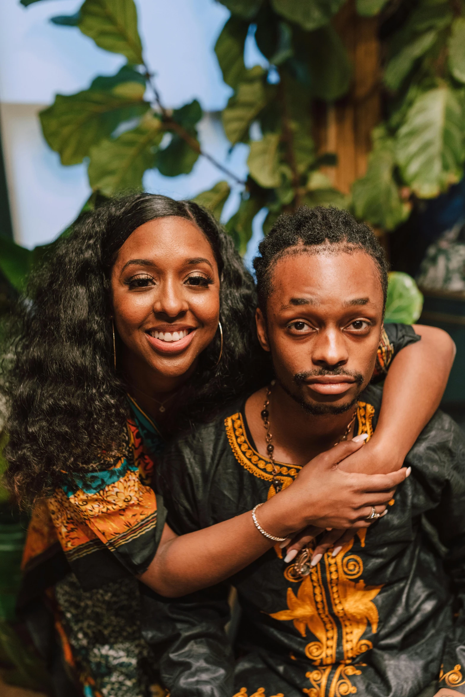 a man and woman sitting next to each other, an album cover, trending on unsplash, renaissance, wearing an african dress, large friendly eyes, sza, headshot profile picture