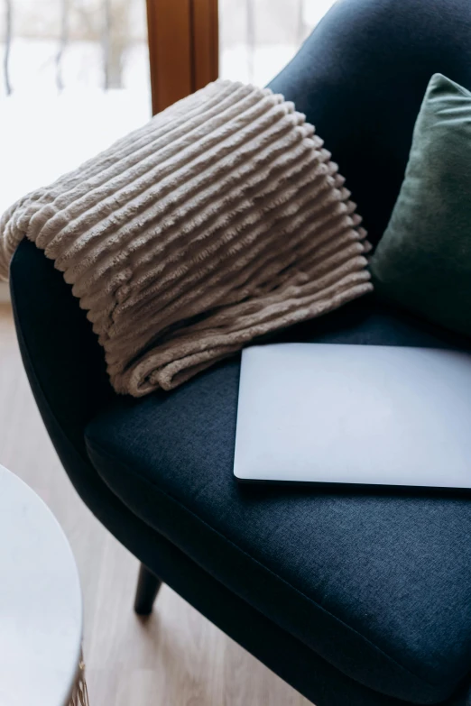 a laptop computer sitting on top of a blue chair, by Carey Morris, trending on pexels, cozy arm chairs, soft surface texture, black chair, cover shot