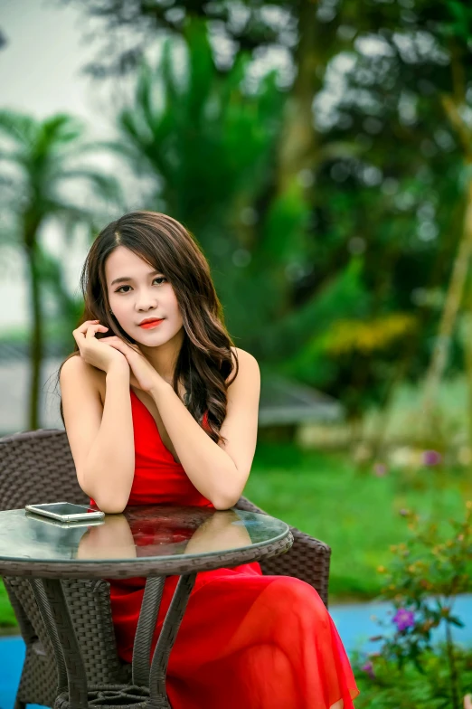 a woman in a red dress sitting at a table, pexels contest winner, young cute wan asian face, square, lush surroundings, dang my linh