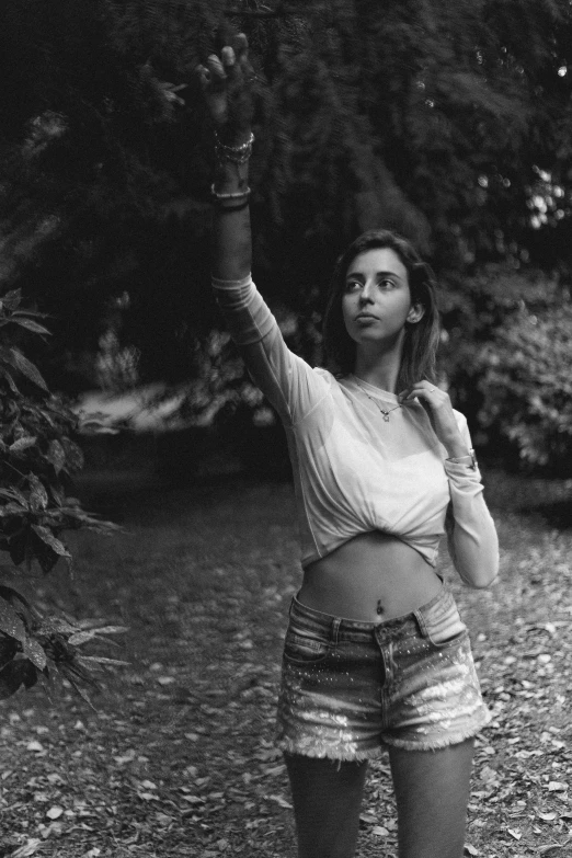 a black and white photo of a woman throwing a frisbee, inspired by irakli nadar, wearing a crop top, ((forest)), ✨🕌🌙, young beautiful amouranth