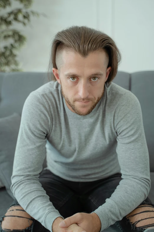 a man sitting on a couch holding a remote control, inspired by Alexey Venetsianov, trending on reddit, renaissance, wavy hair spread out, tight shirt, looking straight into camera, profile image