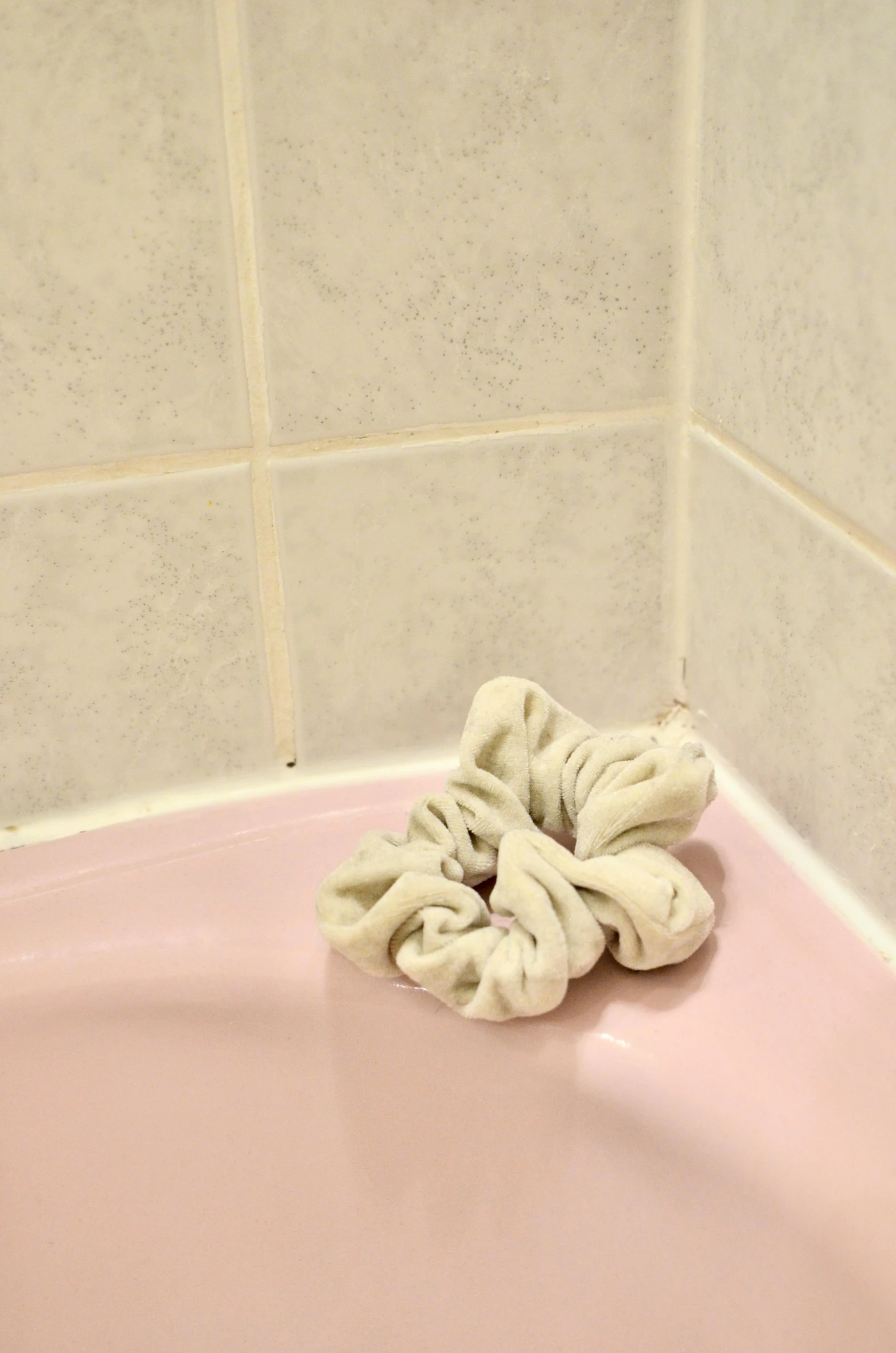 a white towel sitting on top of a pink bath tub, inspired by Sarah Lucas, process art, soft rubber, unkept hair, 2010s, wet clay