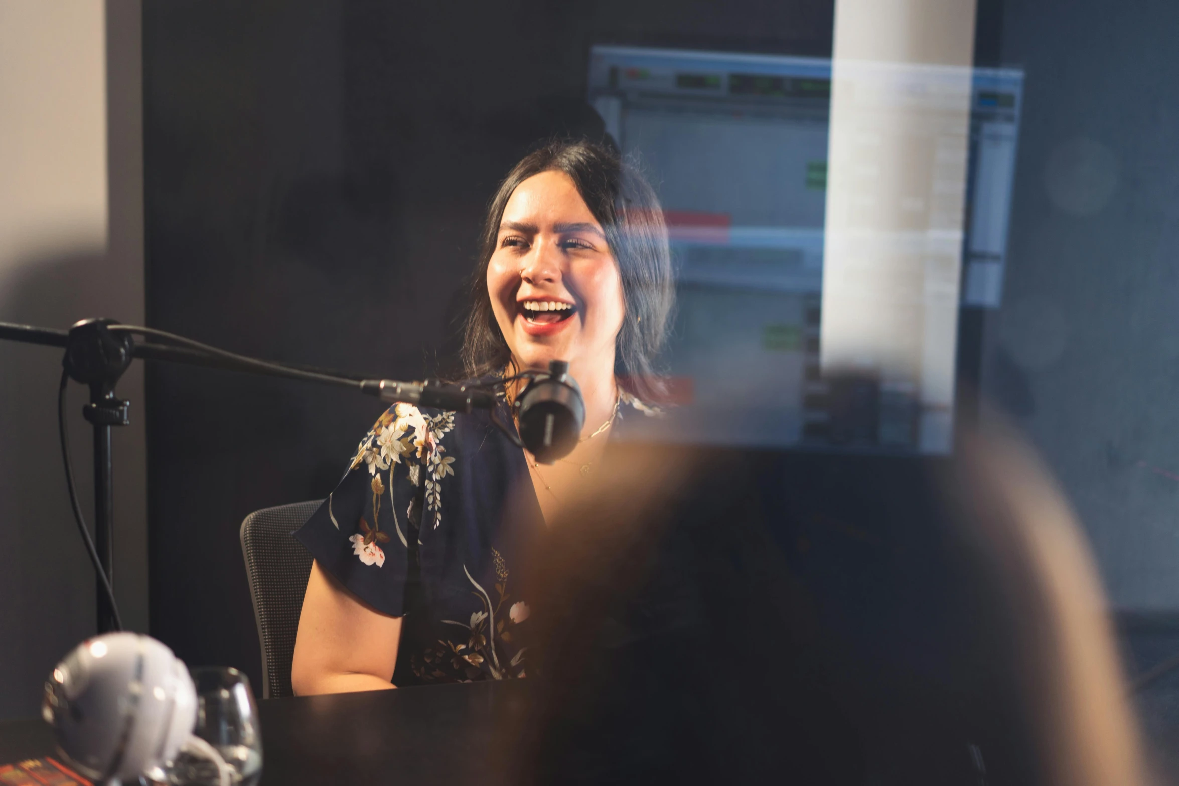 a woman that is sitting in front of a microphone, smiling, charli bowater and artgeem, radio, thumbnail