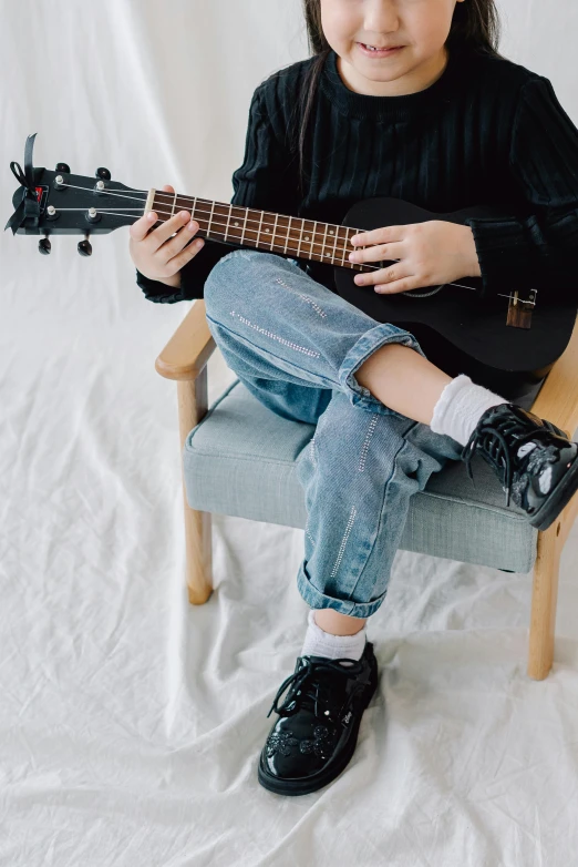 a little girl sitting in a chair with a guitar, trending on unsplash, baggy jeans, wearing kneesocks, teenage boy, black canvas