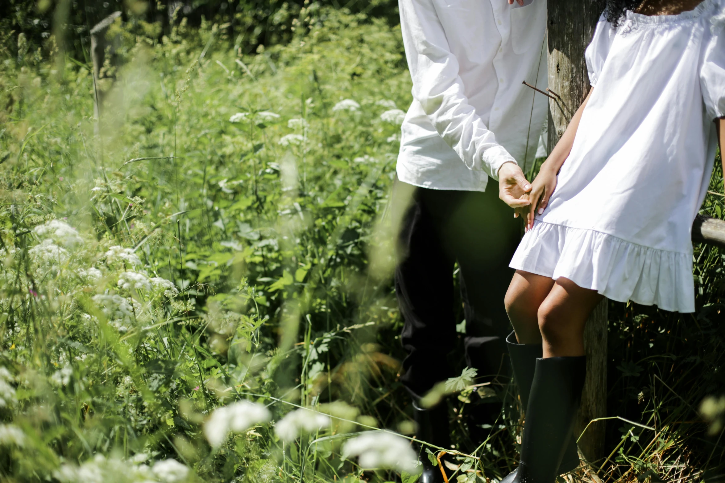 a man and a woman standing next to a tree, inspired by Konstantin Somov, unsplash, dressed as schoolgirl, hiding in grass, leg shot, school uniform