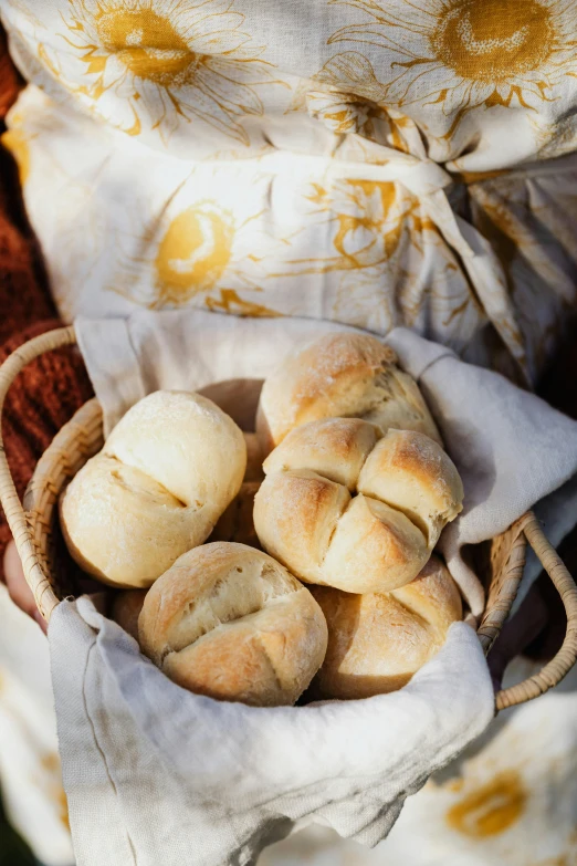 a person holding a basket full of bread, food, linen, sun lighting, cream