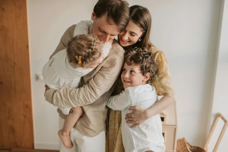 a family poses for a photo in their living room, by Emma Andijewska, pexels contest winner, hugging each other, avatar image, cute photo, close up portrait photo