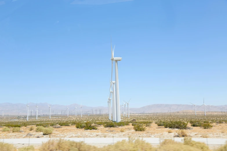 a wind farm in the middle of the desert, unsplash, photorealism, ignant, joel sternfeld, coachella, a green