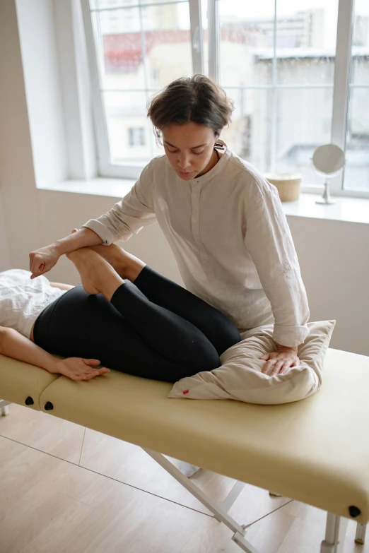 a woman sitting on top of a table in a room, on a white table