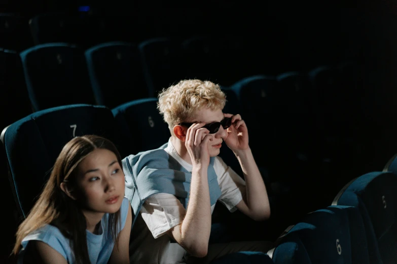 a couple of people sitting next to each other in a theater, trending on pexels, hyperrealism, wearing blue sunglasses, avatar image, luts, ignant