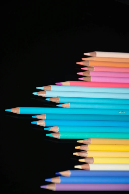 a group of colored pencils sitting on top of each other, a pastel, by Doug Ohlson, neon blue color, color ( sony a 7 r iv, black chalk, monochrome color