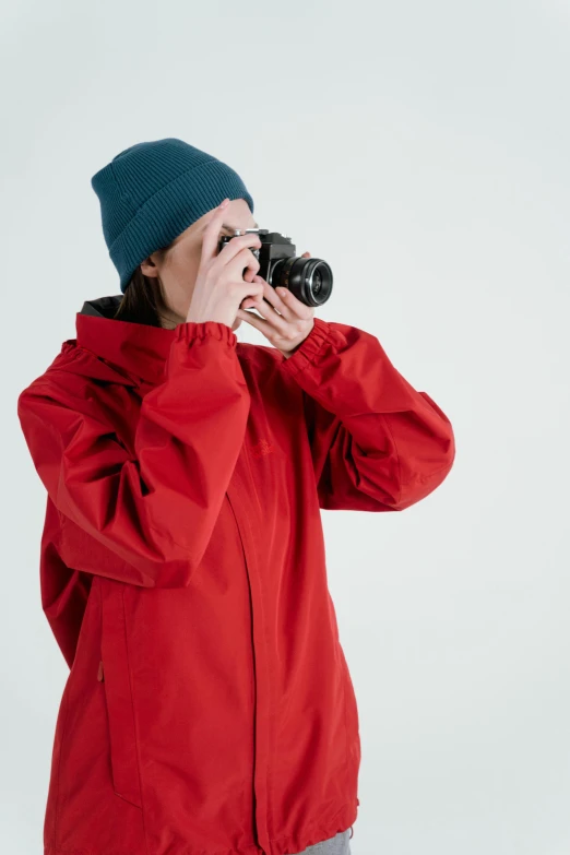 a woman taking a picture with a camera, wearing a scarlet hoodie, technical, thumbnail, drenched clothing