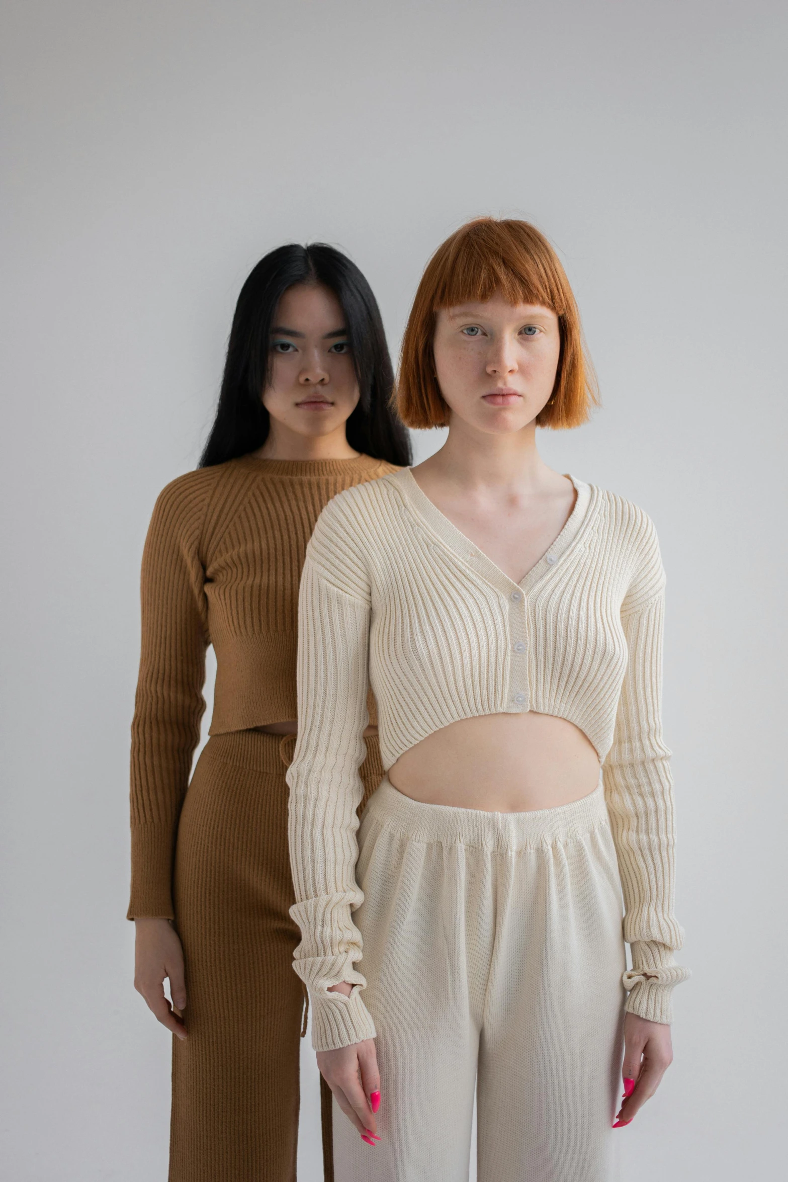 a couple of women standing next to each other, an album cover, inspired by Vanessa Beecroft, renaissance, wearing a cardigan, wearing a crop top, ochre, a young asian woman