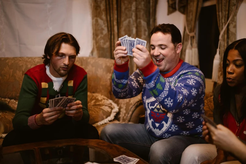 a group of people sitting around a table playing cards, wearing festive clothing, vitaly bulgarov and mike nash, avatar image, lifestyle