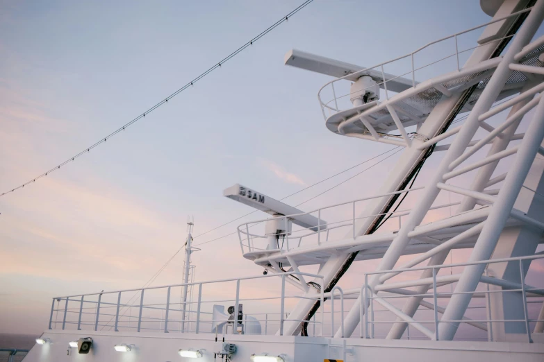 a large white ship sitting on top of a body of water, in the evening, overhead wires, observation deck, high-quality photo