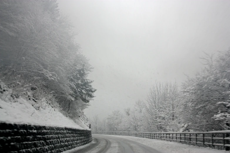 a black and white photo of a snowy road, a picture, pexels contest winner, hilly road, background image, snowstorm ::5, italian