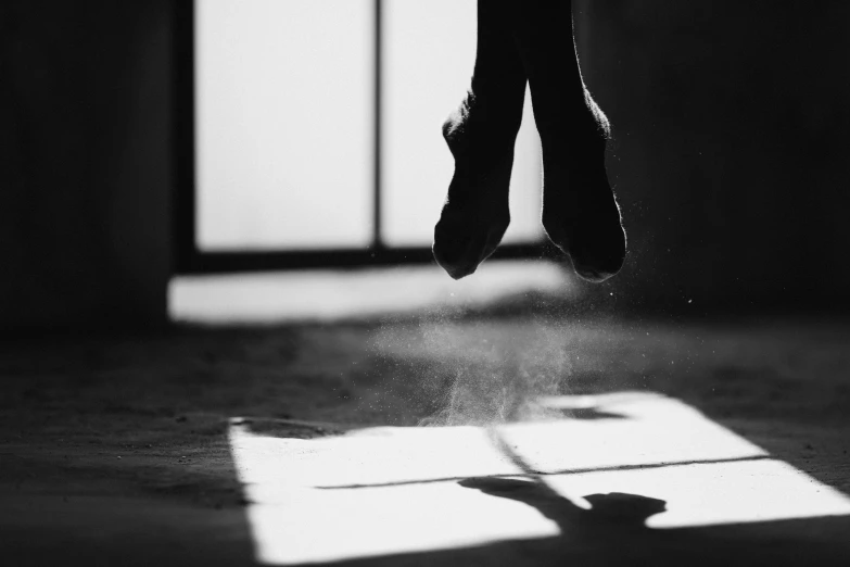 a black and white photo of a person jumping in the air, by Elizabeth Polunin, unsplash, arabesque, window light, hoofs, dusty floor, 15081959 21121991 01012000 4k