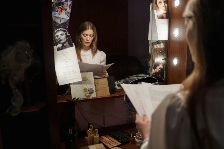 a woman reading a piece of paper in front of a mirror, by Emma Andijewska, pexels contest winner, concert, elle fanning at night, [ theatrical ], studio picture