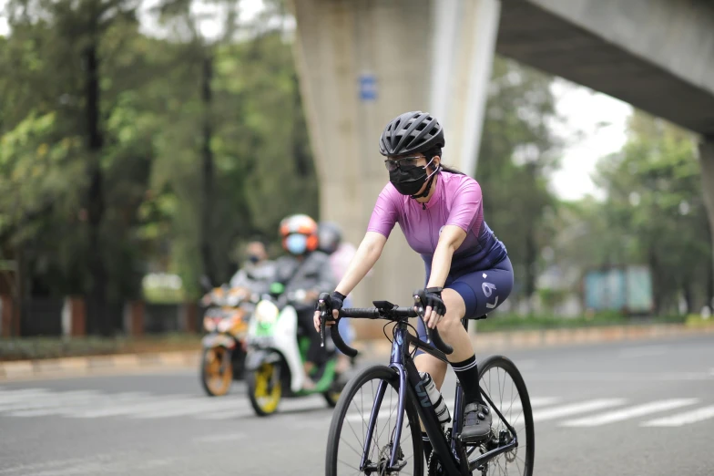 a person riding a bike on a city street, avatar image, mai anh tran, racing, full frame image