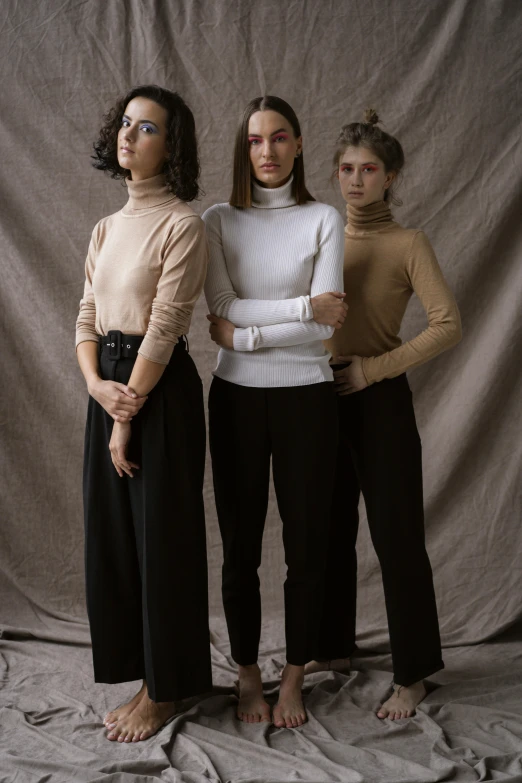 a group of three women standing next to each other, inspired by Vanessa Beecroft, trending on unsplash, renaissance, wearing turtleneck, studio shoot, wearing elegant casual clothes, black trousers