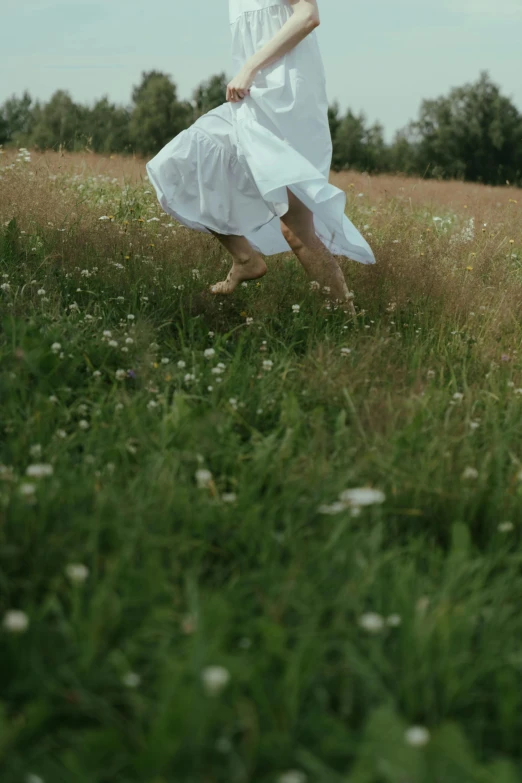 a woman in a white dress running through a field, by Attila Meszlenyi, unsplash, happening, live-action archival footage, 15081959 21121991 01012000 4k, bare feet in grass, midair