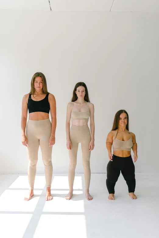 a group of women standing next to each other, inspired by Vanessa Beecroft, trending on unsplash, renaissance, wearing fitness gear, beige, three women, cardboard