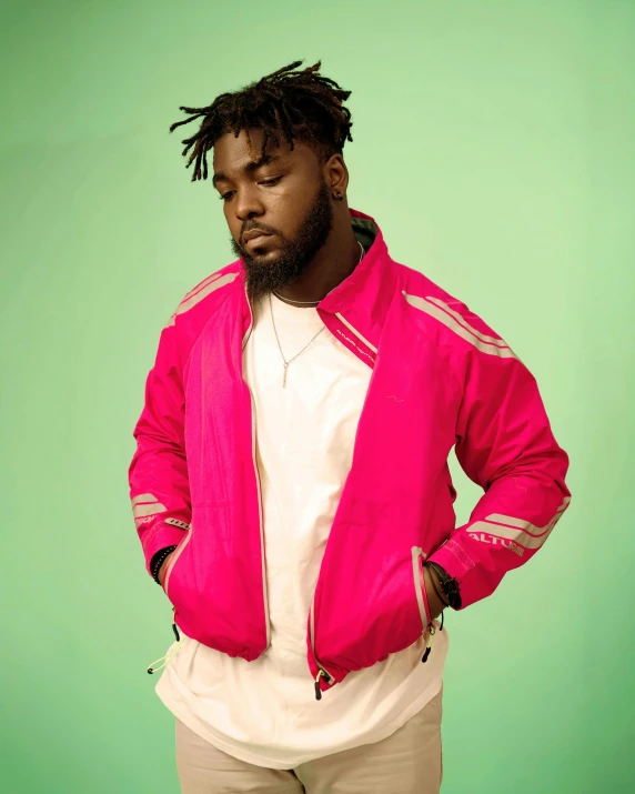 a man in a pink jacket standing with his hands in his pockets, an album cover, inspired by Charles Martin, trending on pexels, model wears a puffer jacket, wearing track and field suit, roygbiv, press shot