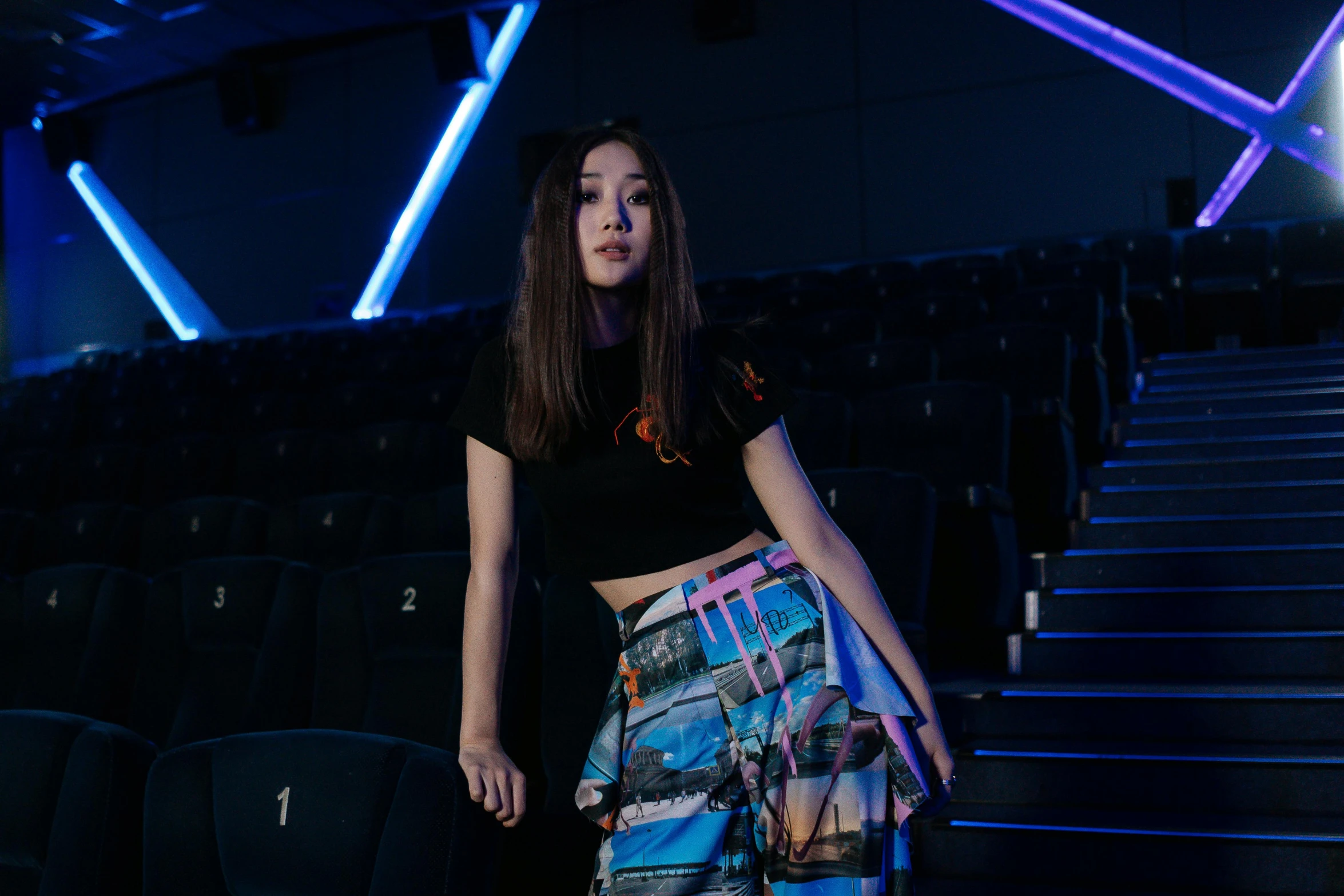 a woman standing in front of a stage, inspired by Leng Mei, unsplash, lyco art, sitting in a movie theater, techwear clothes, avatar image, hong june hyung