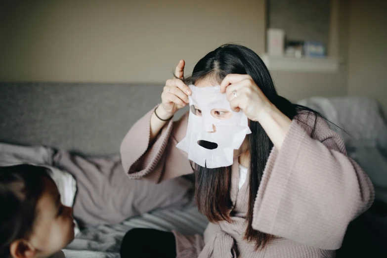 a woman covering her face with a sheet of paper, pexels contest winner, mingei, face mask, avatar image, square face, at home
