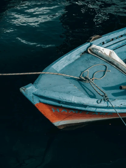 a blue boat sitting on top of a body of water, pexels contest winner, dark grey and orange colours, on the bow, blue and white color palette, thumbnail